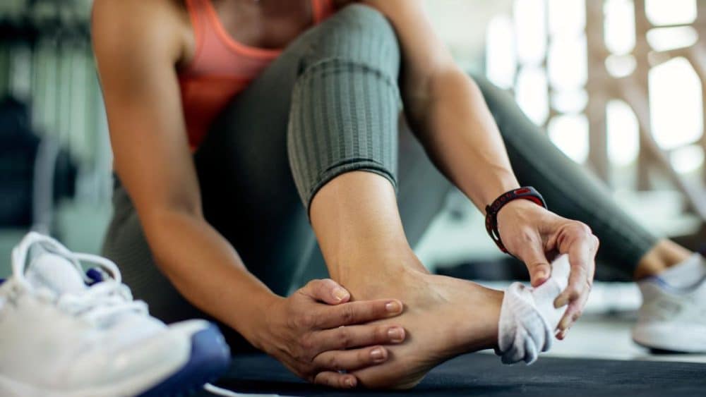 closeup-athletic-woman-injured-her-foot-during-workout-gym